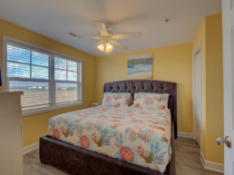 yellow painted motel room with big windows and large bed