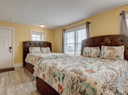 motel room with with two beds with coral reed pattern comforters on top